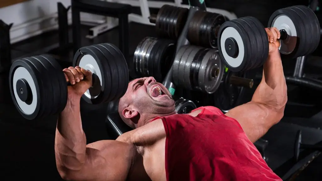 guy doing dumbbell press struggling